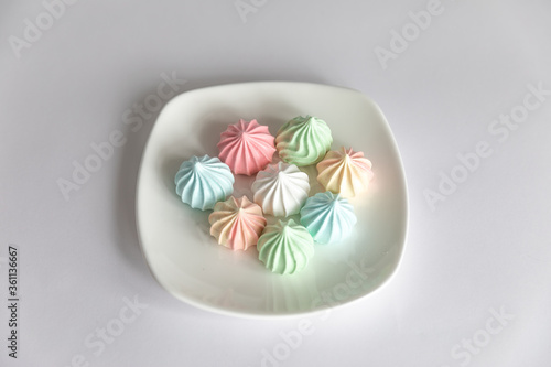 meringues on saucer on isolated white background.