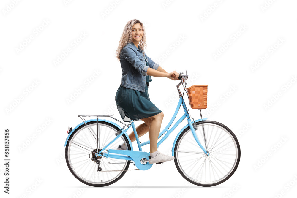 Side shot of a young female riding a bicycle and looking at the camera Side shot of a young female riding a bicycle and looking at the camera