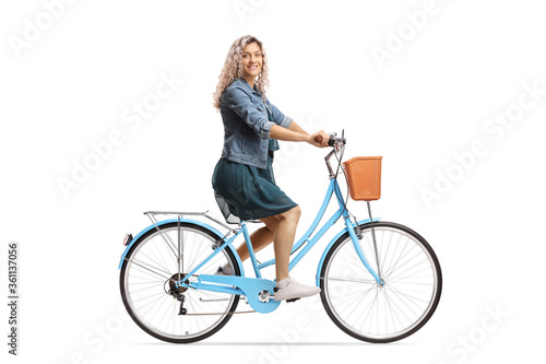 Side shot of a young female riding a bicycle and looking at the camera