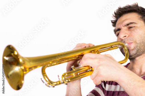 Trumpet player, plays the instrument, eyes are half open and blowing / isolated white background
