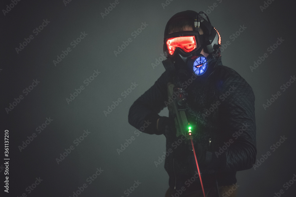 Futuristic soldier in led light helmet with a rifle on dark background. Futuristic soldier in led light helmet with a rifle on dark background.