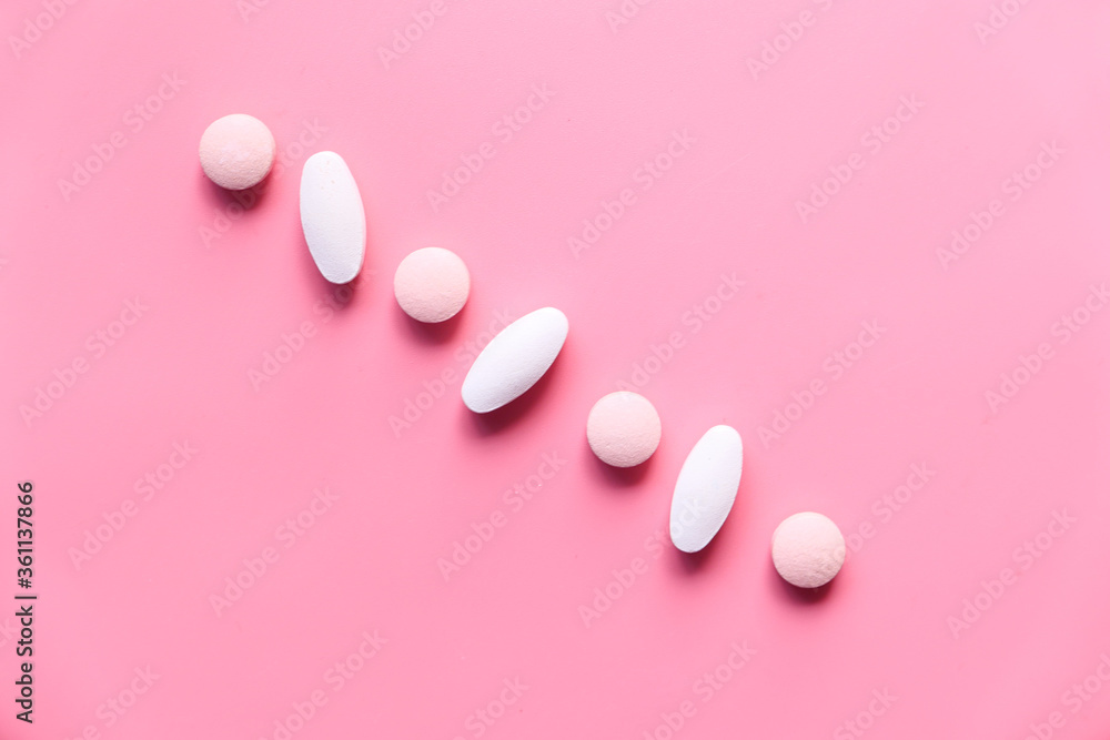 white and pink color pills on pink background white and pink color pills on pink background