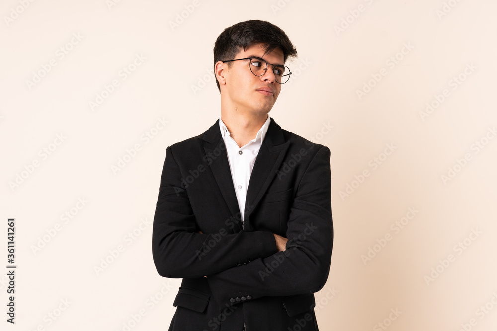 Businessman over isolated beige background thinking an idea Businessman over isolated beige background thinking an idea