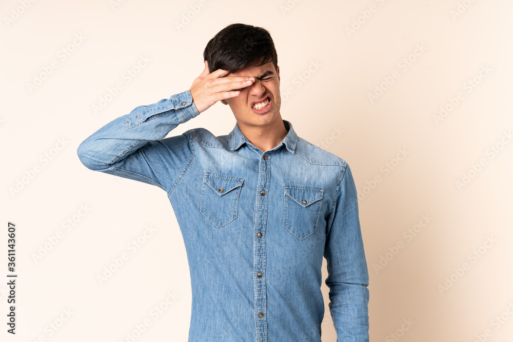 Handsome man over isolated beige background with tired and sick expression Handsome man over isolated beige background with tired and sick expression