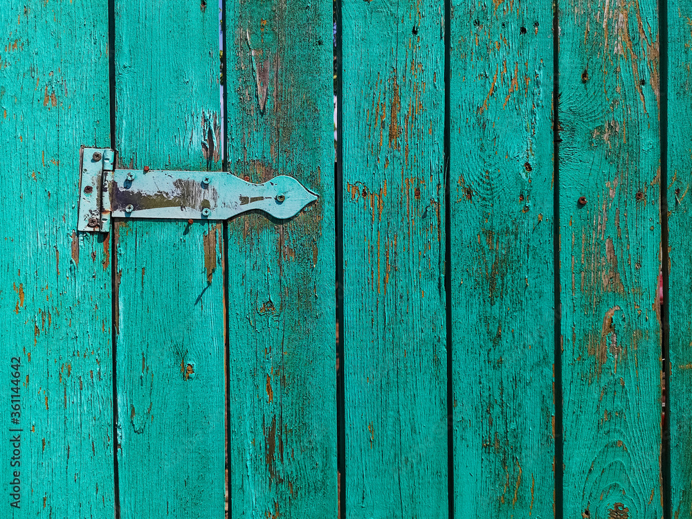 Old rusty door hinge on a wooden fence door. Old rusty door hinge on a wooden fence door.