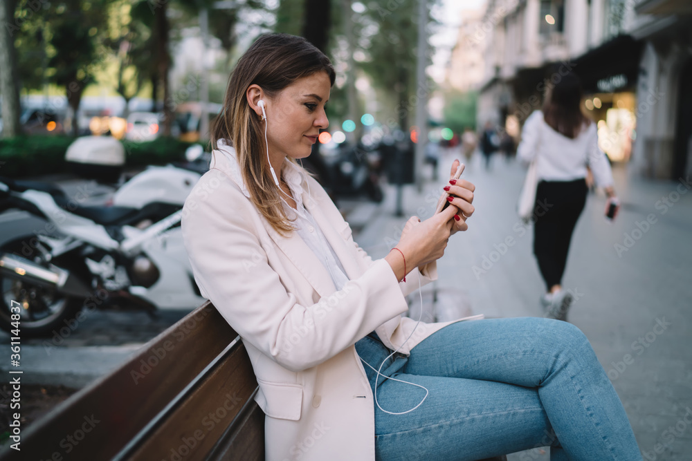 Young woman using smartphone while sitting on bench Young woman using smartphone while sitting on bench