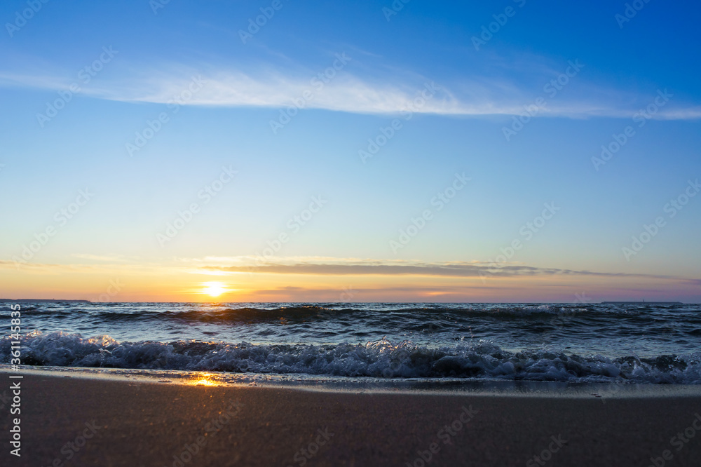 Sunset over the sea. Reflection of sunlight in the sea waves. The sky in the sunset rays. Russia Baltic Sea.