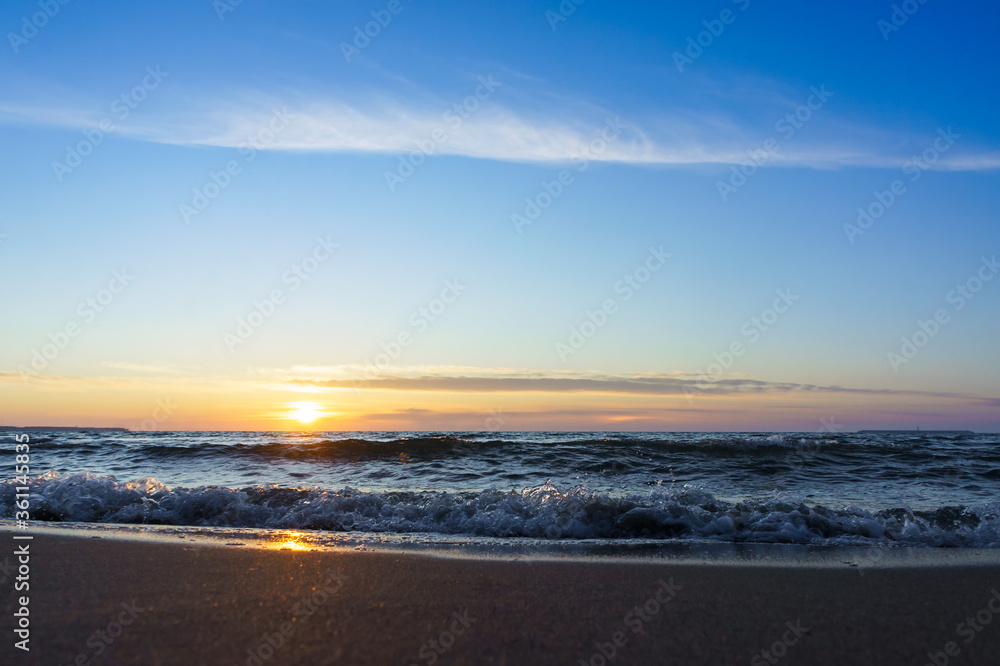 Obraz premium Sunset over the sea. Reflection of sunlight in the sea waves. The sky in the sunset rays. Russia Baltic Sea.