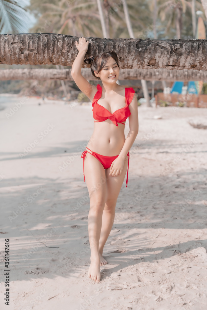 Fototapeta premium Young sexy woman in bikini enjoying summer vacation on beach relaxing holiday