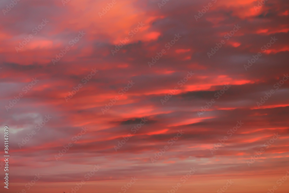Orange sky background at sunset with heap thick clouds