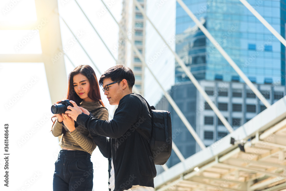 Happy young traveller couple of tourists looking photo in camera in the city. Happy young traveller couple of tourists looking photo in camera in the city.