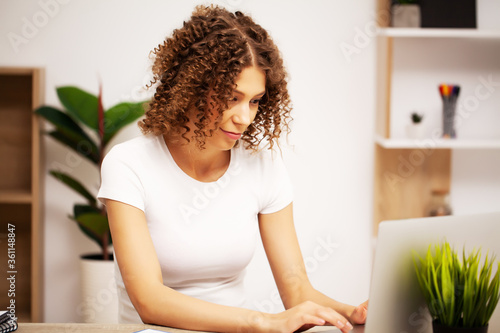 Beautiful business woman with a smile on her face working in the office on a laptop