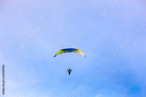 A flying paramotor on a vibrant sky with cloud.