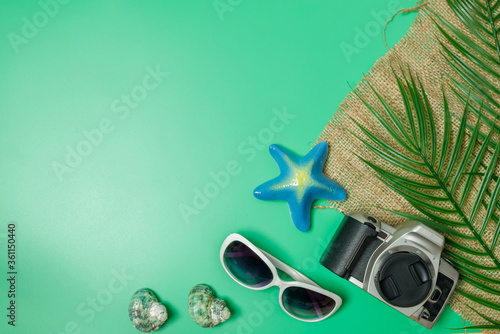 The beach accessories on the green background. Summer is coming concept. vacation and travel concept. photo