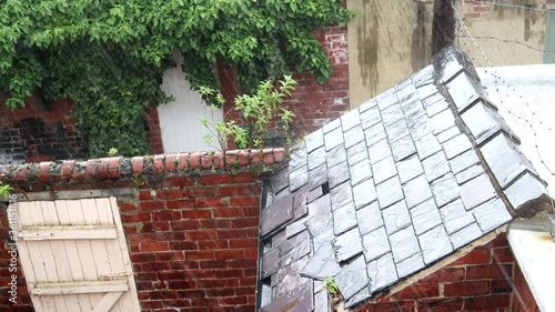 Heavy Summer Rain Falling On a Broken Slate Outhouse Roof In The United Kingdom 