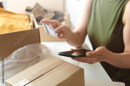 Online payment by mobile phone and credit card. The woman received a delivery box with goods.