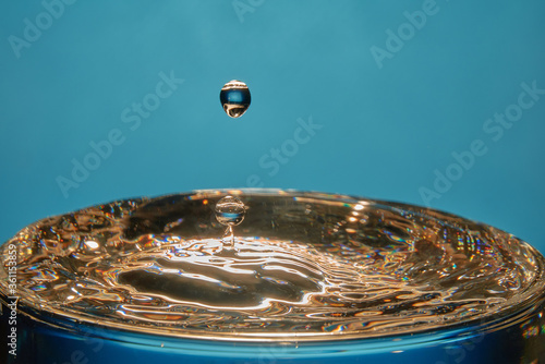  Falling water drop collision with beautiful colorful reflections and waves pattern