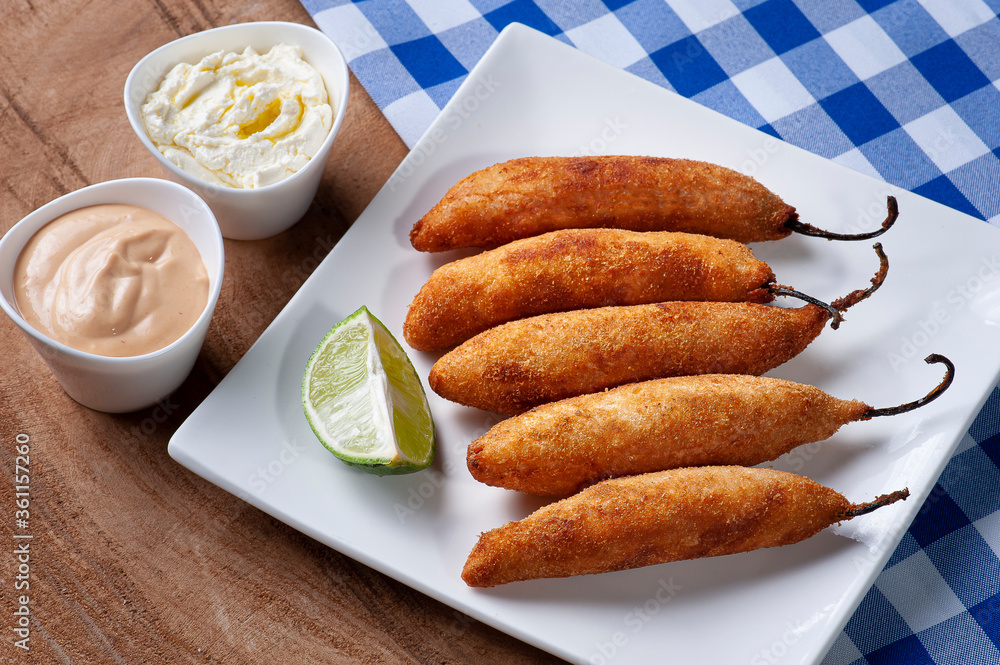 .Peppers stuffed with cheese, breaded and fried. Accompanied with curd, rose sauce and lemon .Peppers stuffed with cheese, breaded and fried. Accompanied with curd, rose sauce and lemon