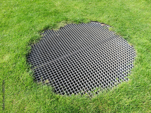 Tableau sur toile round metal grid in a grass field above an airshaft