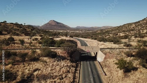 4K aerial drone video of African savanna hills, railway bridge over B1 highway south of Windhoek in central highland Khomas Hochland of Namibia, southern Africa photo