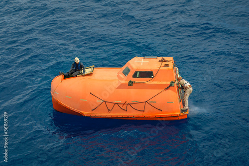 freefall lifeboat in the water with two seamen onboard 