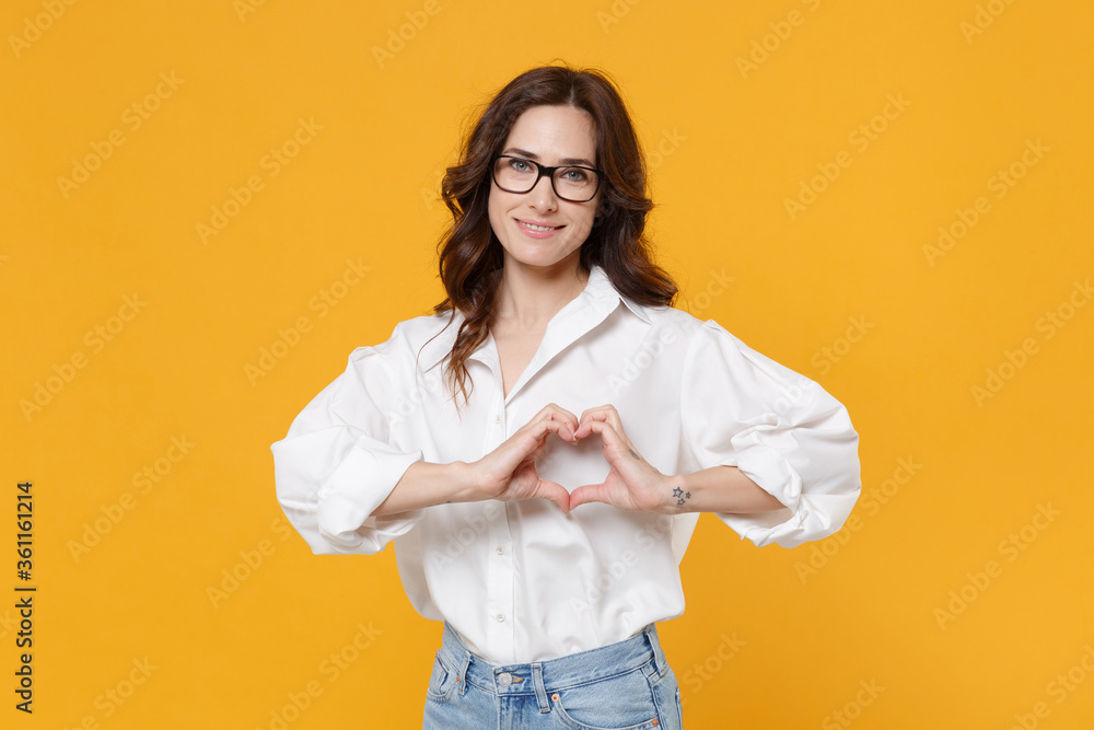 Smiling brunette business woman in white shirt glasses isolated on yellow background. Achievement career wealth business concept. Mock up copy space. Showing shape heart with hands, heart-shape sign. Smiling brunette business woman in white shirt glasses isolated on yellow background. Achievement career wealth business concept. Mock up copy space. Showing shape heart with hands, heart-shape sign.