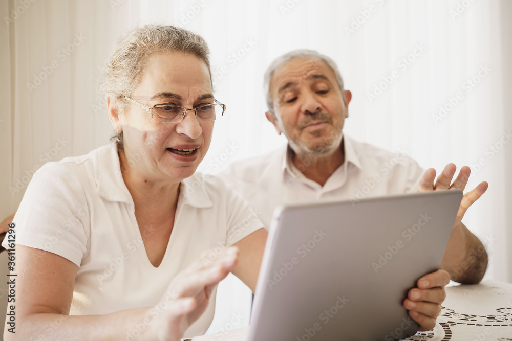 The elderly couple trying to use the tablet show each other something on the screen. old couple is trying to talk to their grandchildren. old couple is trying to talk to their children. The elderly couple trying to use the tablet show each other something on the screen. old couple is trying to talk to their grandchildren. old couple is trying to talk to their children.