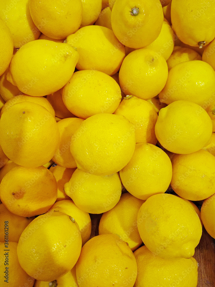 a large pile of ripe yellow lemons for sale on a counter in a store