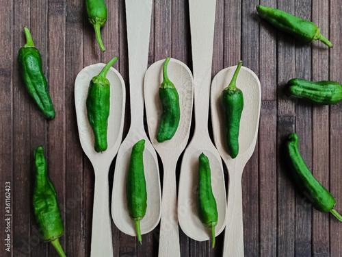 Padrón peppers background on spoon and wooden table