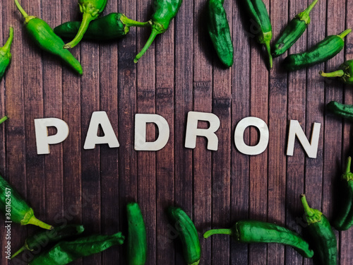 Padrón peppers background on a wooden table with the word that says Padrón in wooden letter