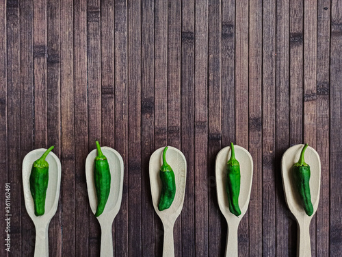 Padrón peppers background on spoon and wooden table