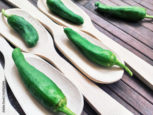 Padrón peppers background on spoon and wooden table