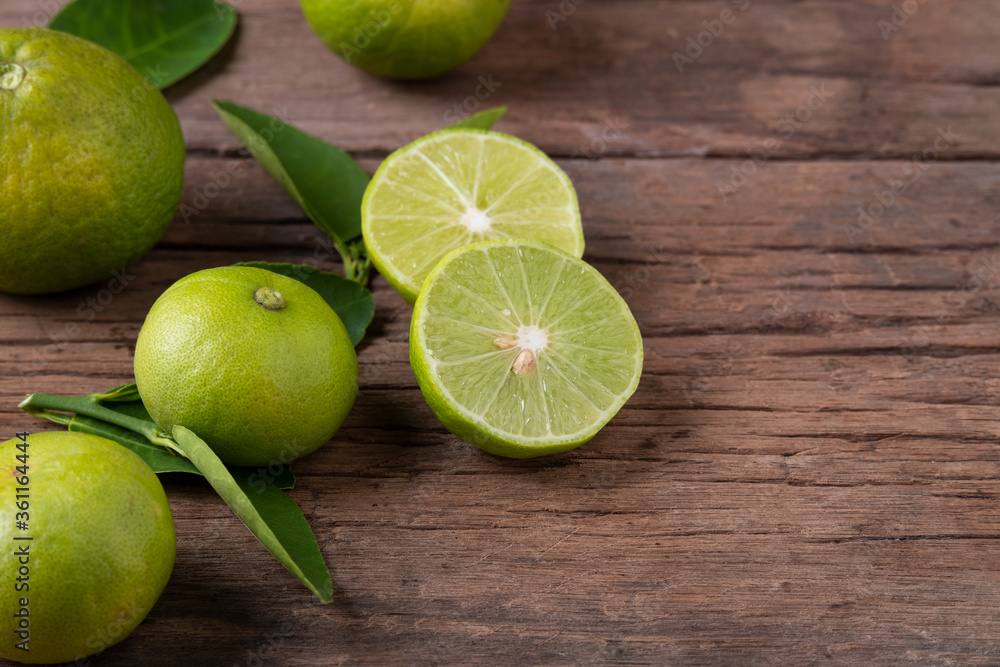 Half sliced lime fruits on wood plate Half sliced lime fruits on wood plate