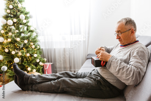 old age, holidays, problem and people concept - senior man in glasses thinking at home over christmas tree background