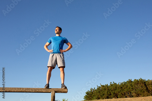 man standing on bench looking confident