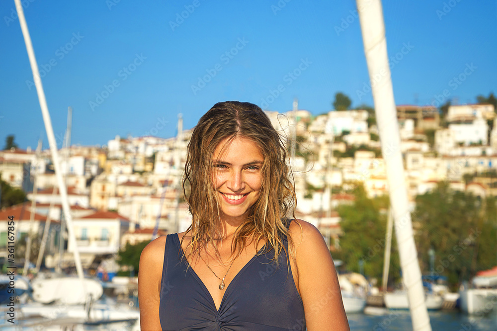 Young happy woman in sunglasses feels fun on the luxury sail boat yacht catamaran in turquoise sea in summer holidays, Greece.