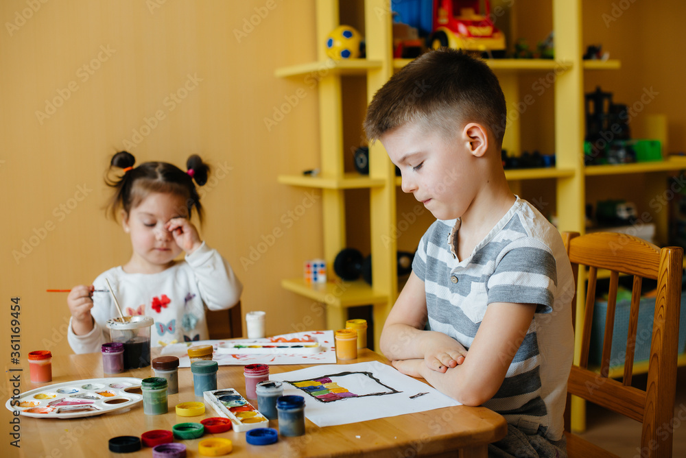A boy and a girl play together and paint. Recreation and entertainment. Stay at home A boy and a girl play together and paint. Recreation and entertainment. Stay at home