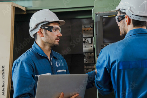 Factory Engineer or mechanical worker with white safety helmet checking on production in a factory. Industrial,Warehouse Heavy Mechanic, Engineering Concept.
