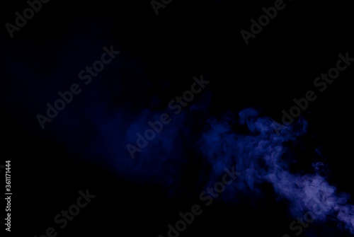 White smoke on a black background. Colored smoke with a blue and purple tinge. The texture of scattered smoke. Blank for design. Layout for collages.