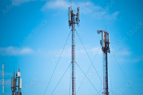Technology on the top of the telecommunication GSM. Masts for mobile phone signal. Tower with antennas of cellular communication on the background of blue sky.