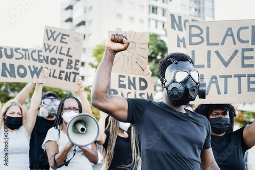 Activist wearing gas mask protesting against racism and fighting for equality - Black lives matter demonstration on street for justice and equal rights - Blm international movement concept photo