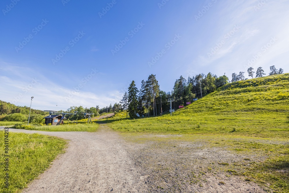 Beautiful landscape view of hill with slalom lift on blue sky background on sunny summer day. Sweden. Europe. Uppsala
