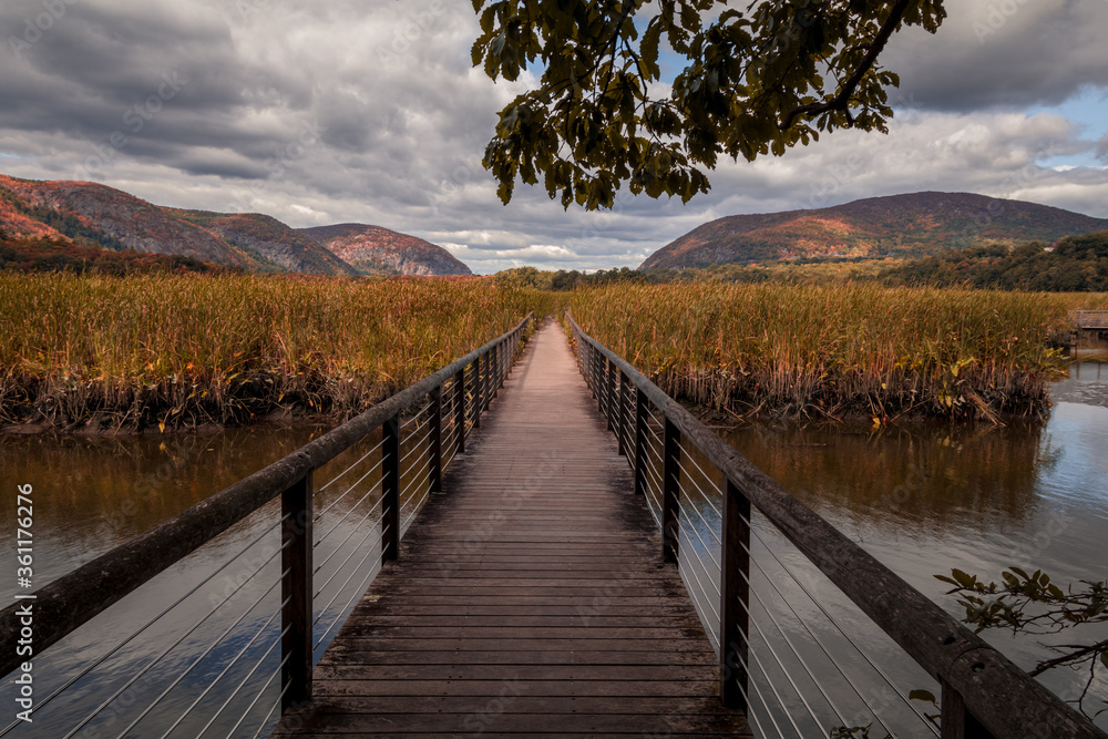 Obraz premium Constitution Marsh bridge along the Hudson River, NY, with early fall foliage