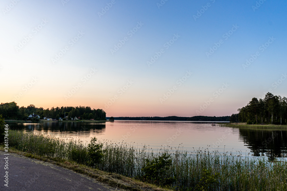 Sunset over lake with kids playing on a raft. Night swimming. Swimming at sunset.