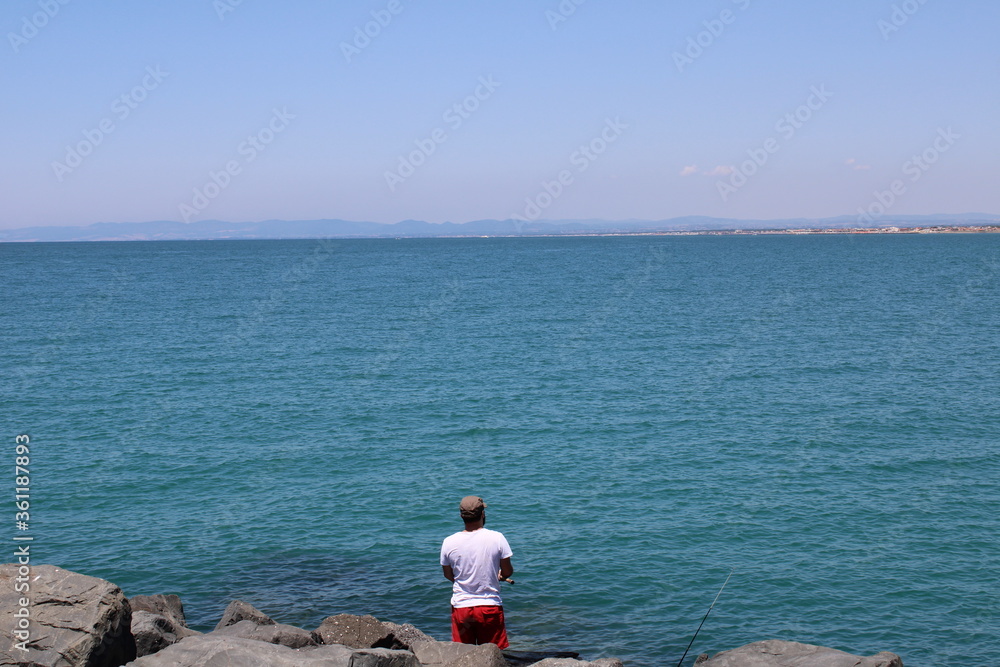  man fishing on the beach 