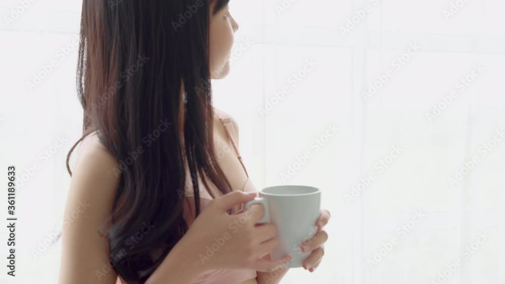Beautiful young asian woman happy and confident drinking cup of coffee with fresh and looking windows at home, lifestyle asia girl relax in the room at home for wellness and health concept. Beautiful young asian woman happy and confident drinking cup of coffee with fresh and looking windows at home, lifestyle asia girl relax in the room at home for wellness and health concept.