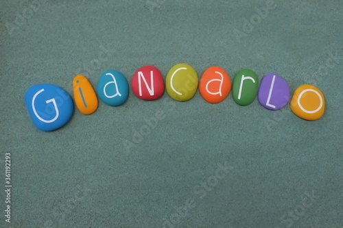 Giancarlo, masculine italian given name composed with multicolored stone letters over green sand
