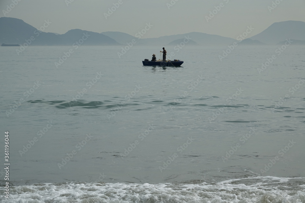 Silhouette of people on fishing boat in the ocean