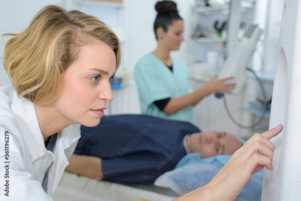 young female doctor setting up x-ray machine young female doctor setting up x-ray machine
