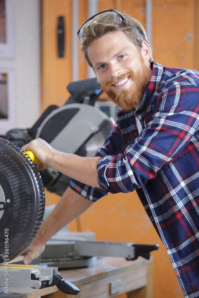 portrait of happy male carpenter with circular saw portrait of happy male carpenter with circular saw